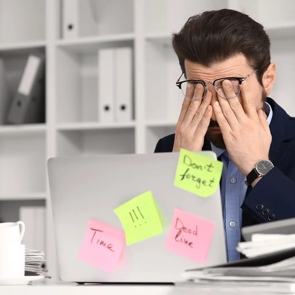 Mann gestresst im Büro vor seinem Laptop